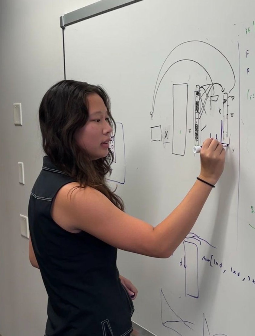 Kristi Xing writing on a whiteboard